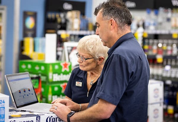 Super Liquor franchise manager Paul Webster discusses sales data with store manager Robyn Neame